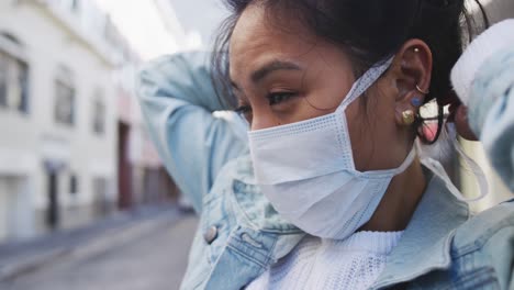 Frau-Repariert-Medizinische-Coronavirus-Maske-Auf-Der-Straße