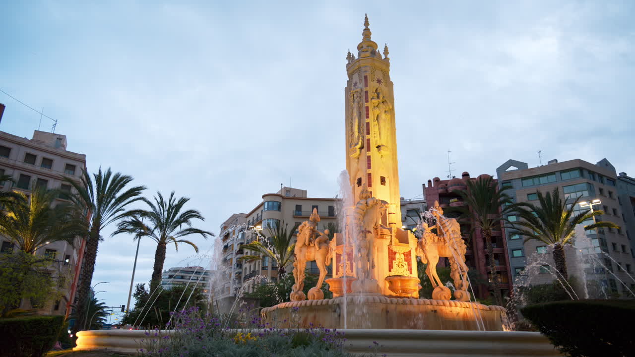 Alicante, Spain - May 19, 2025: People moving through the Plaza de los Luceros Fountain at blue hour