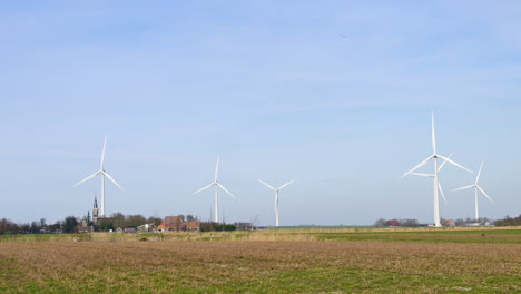 Windräder-Auf-Einem-Landwirtschaftlichen-Feld-Rund-Um-Ein-Kleines-Dorf-In-Den-Niederlanden,-Europa