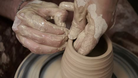 the potter makes a jug of clay. ceramist. a man makes a vase on a potter's wheel