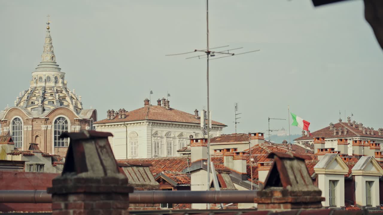 Torino, Italy. The Italian flag flies above the red rooftops of Turin's Old Town next to the Turin Cathedral