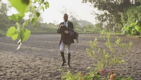 African-American-man-walking-with-the-saddle-of-Dressage-horse