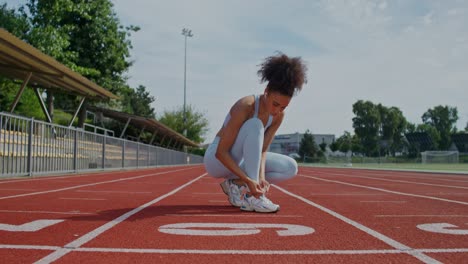 woman tying shoes on a running track