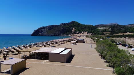 Tsambika-beach-in-Faliraki,-Rhodes-in-Greece-filmed-with-the-drone-from-above-with-Mediterranean-Sea-in-the-summer-holiday