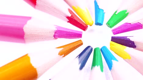 multicolored children's pencils rotate on a white background.