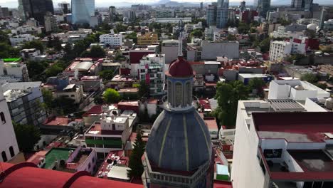 Mixcoac-Kirchturm,-Kirchturm,-Kuppel-Und-Stahlkreuz-In-Der-Innenstadt-Von-Mexiko,-Gebäude-Im-Stadtzentrum,-Rote-Dächer-Und-Skyline,-Aufsteigende,-Nach-Unten-Geneigte-Kreisantenne