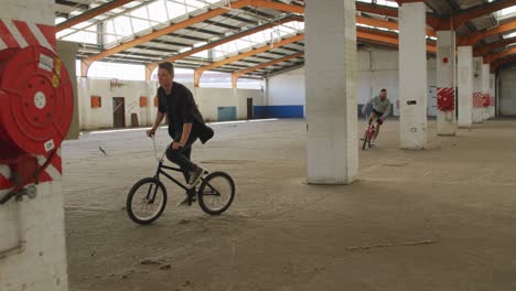 Jinetes-De-Bmx-En-Un-Almacén-Vacío