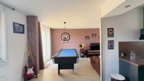 camera glides through a bright, retro-inspired apartment lounge featuring a billiard table, vintage decor, exposed brick, and modern kitchen under natural daylight