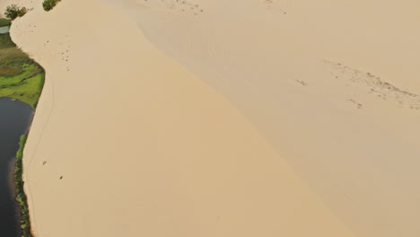 a small pond in the white sand dunes area near mui ne