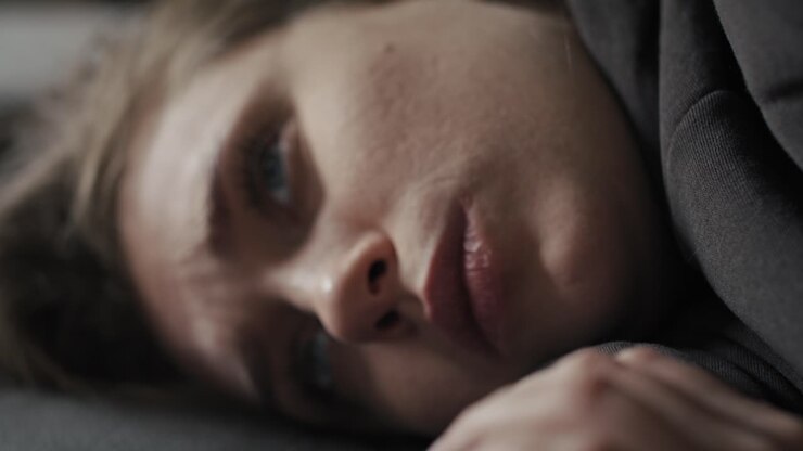 Donna caucasica depressa sdraiata sul divano.