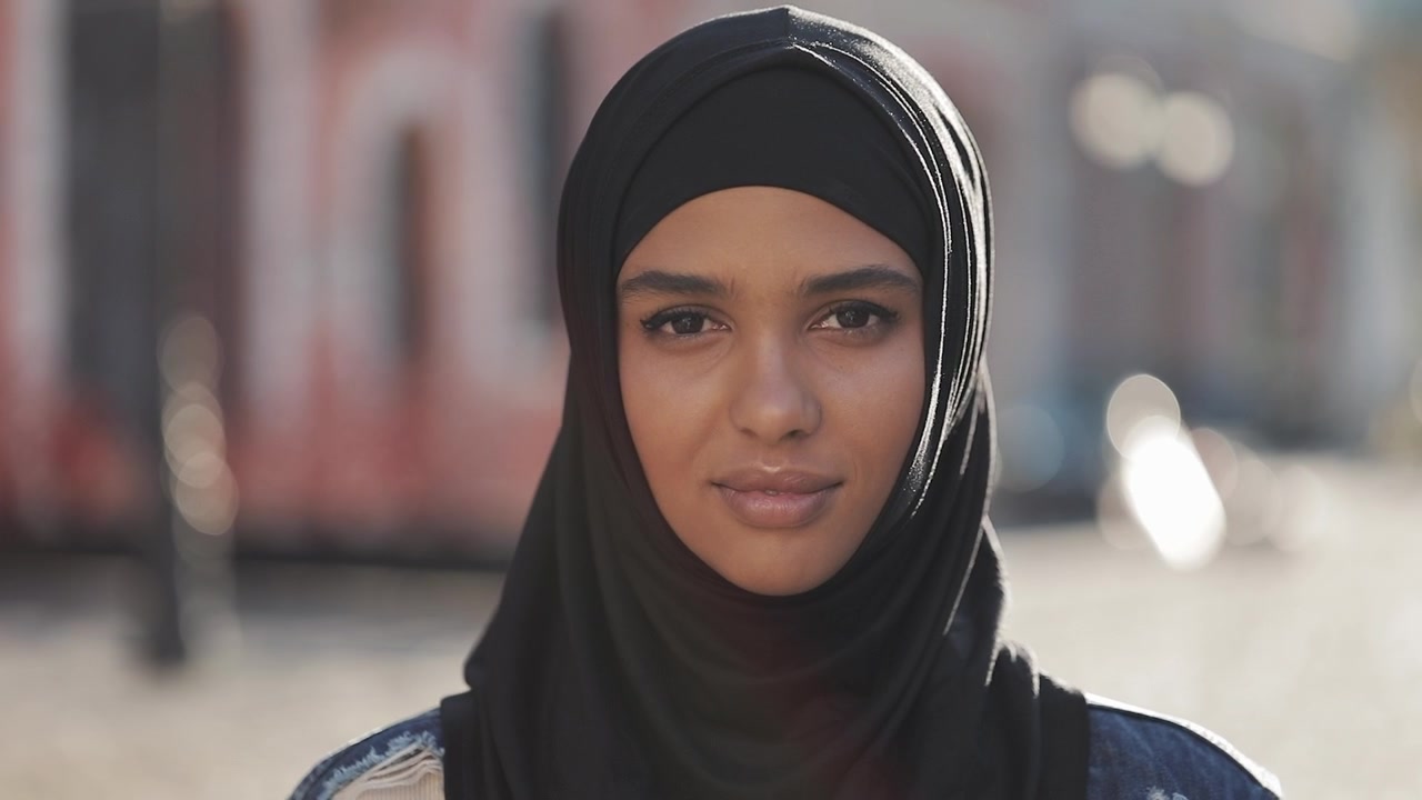 Retrato de una mujer joven con un hiyab negro al aire libre