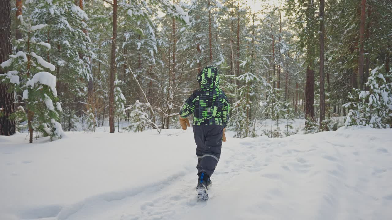 Child walking in a snowy forest