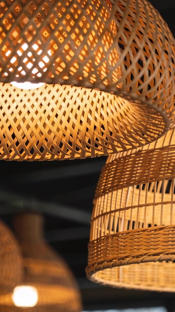 Video verticale: Telecamera che si inclina mostrando due lampade intrecciate in un caffè, evidenziando lampadine calde e ombre.