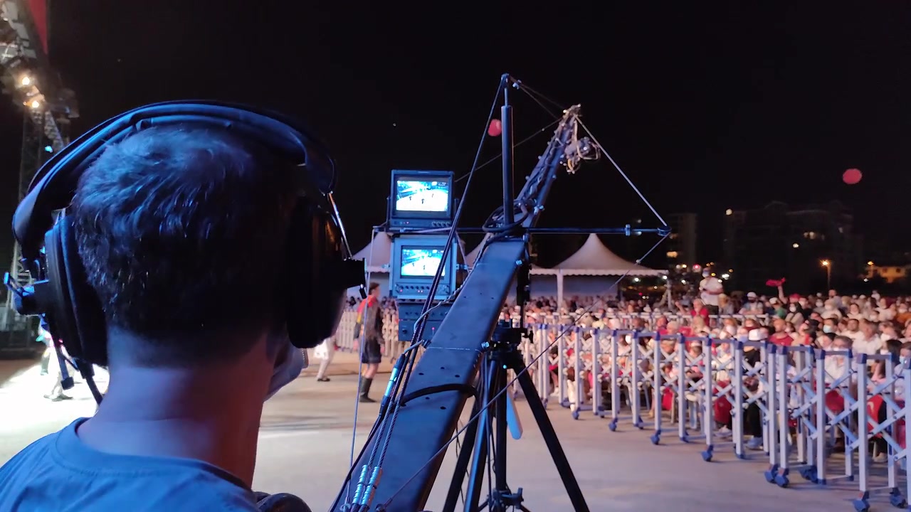 Cameraman Operating Jib Crane at Nighttime Outdoor Event