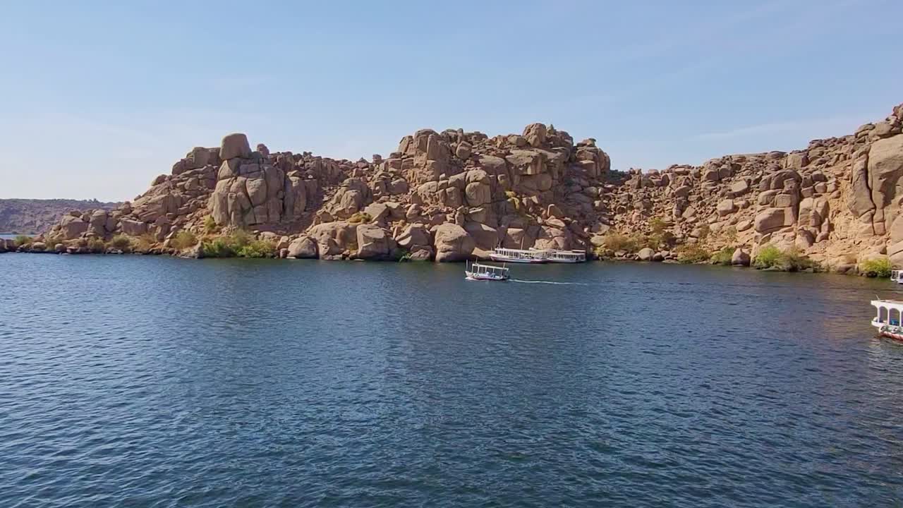 Port with barges on the Nile River next to the Temple of Philae