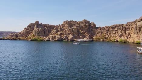 port with barges on the nile river next to the temple of philae