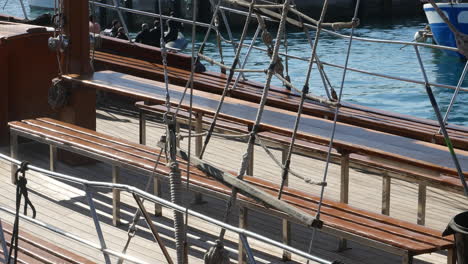 close-up on a wooden ship deck with detailed rigging, evoking maritime heritage and the allure of sailing adventures on crystal waters