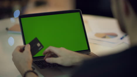 male hands typing credit card data on laptop