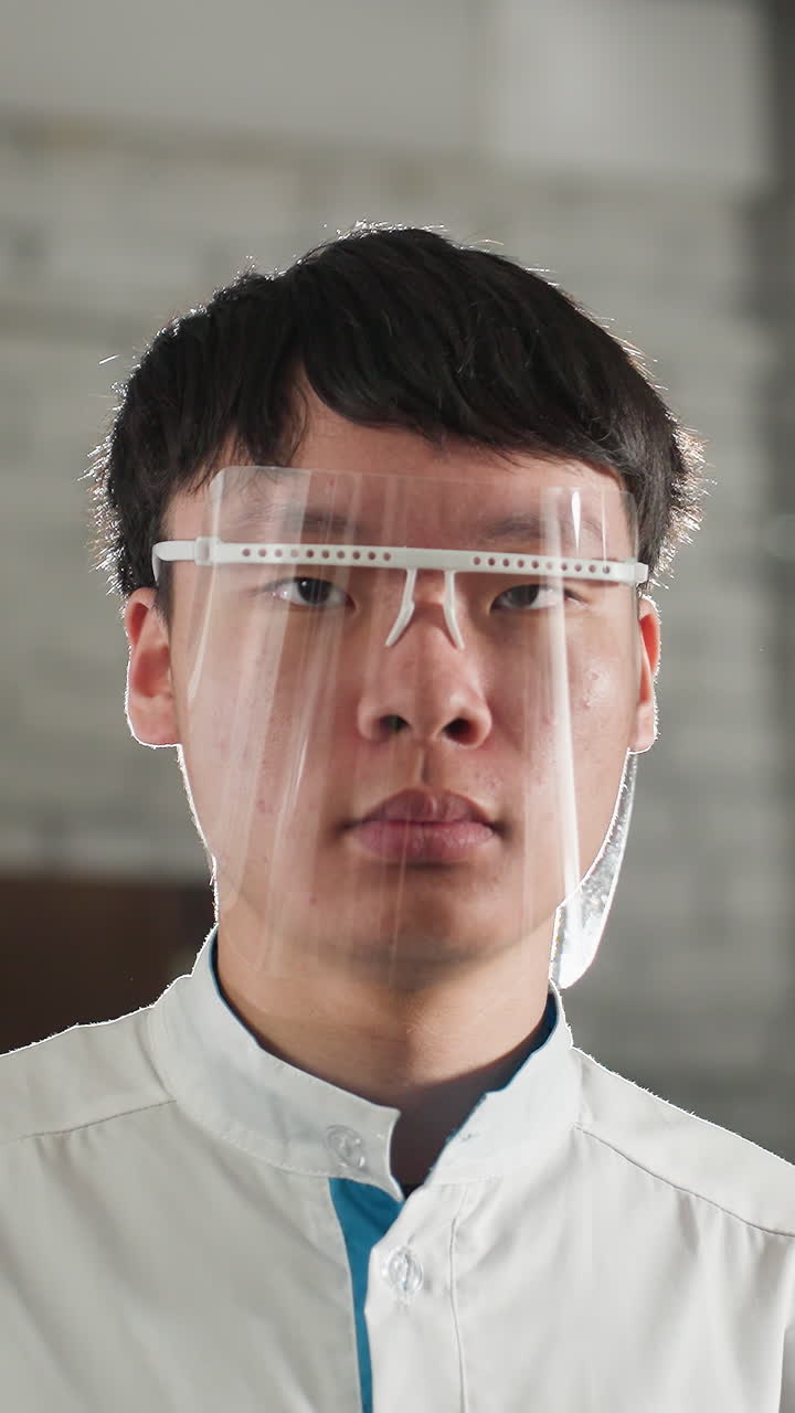 primer plano de un ingeniero en bata de laboratorio ajustando gafas de protección en un taller automotriz, expresión enfocada, antecedentes industriales con herramientas y maquinaria