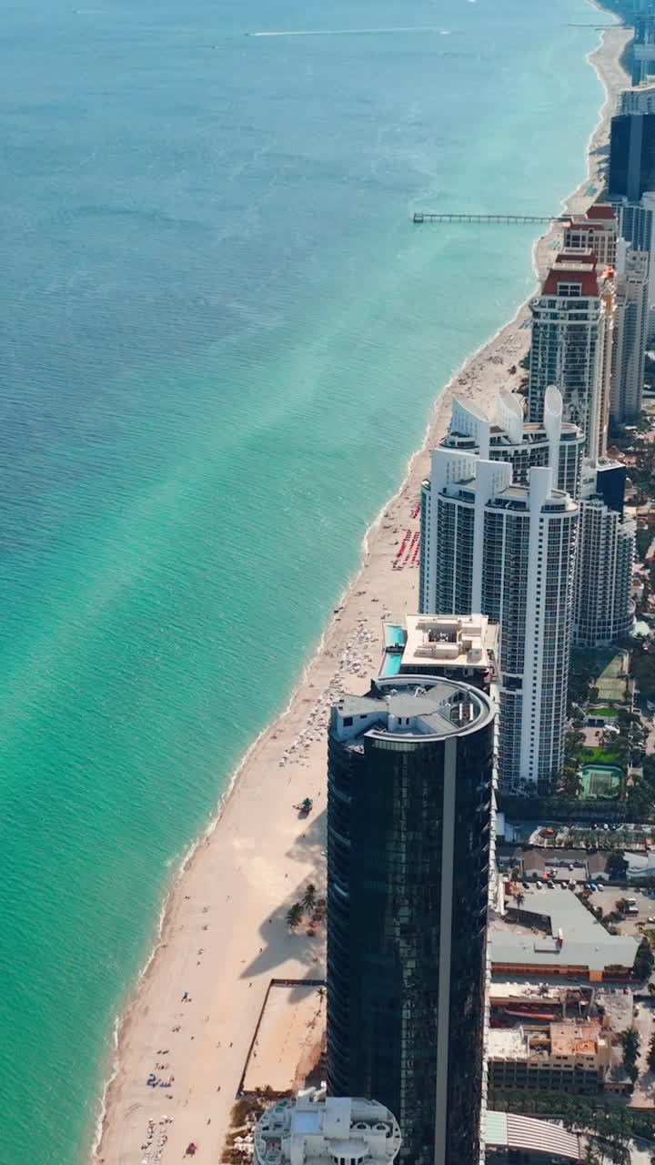 Pláž na pobřeží Atlantiku. Luxusní hotelové apartmány Sunny Isles Beach. Letecké záběry z dronu. Vertikální video