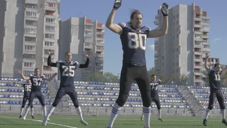 jugadores de fútbol americano calentándose