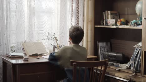 child studying at a wooden desk