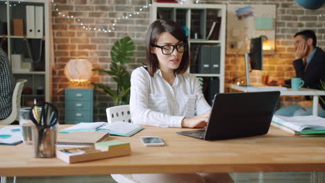 mujer trabajando en una computadora portátil en una oficina moderna