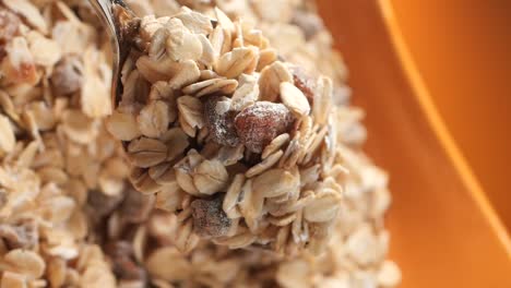 muesli or granola being scooped and poured with a spoon