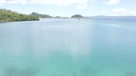 Stunning-View-Of-The-Clear-Blue-Beach-Water-With-Coral-Reef-On-The-Shallow-Bottom-In-A-Paradise-Island-In-The-Philippines---Low-Aerial-Drone-Shot