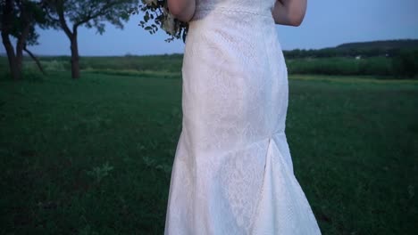 a bride stands in a field