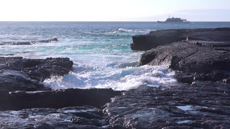 An-elegant-yacht-moves-along-the-shore-of-the-Galapagos-Islands