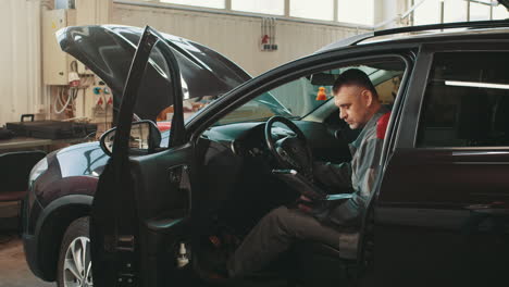 mecánico de automóviles inspeccionando un vehículo en un garaje