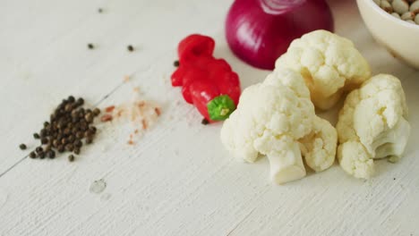 video of fresh vegetables and salt and pepper with copy space over grey background