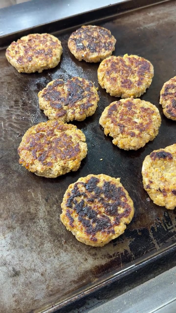 Chef Grilling Fresh Burger Patties on a Commercial Flat Top Grill