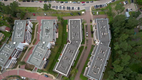 Aerial-view-of-a-complex-of-buildings-with-HVAC-units-on-rooftops-surrounded-by-trees