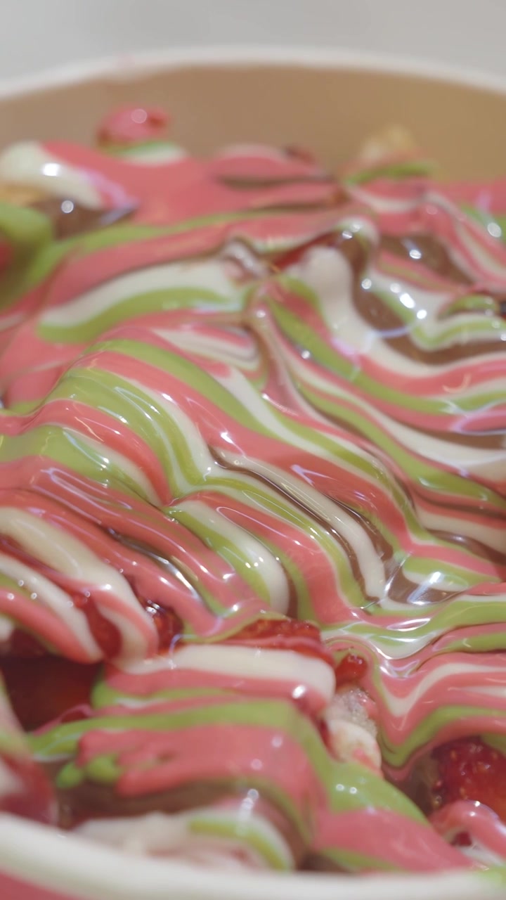 Primo piano di salsa al cioccolato colorata versata a filo su un dessert