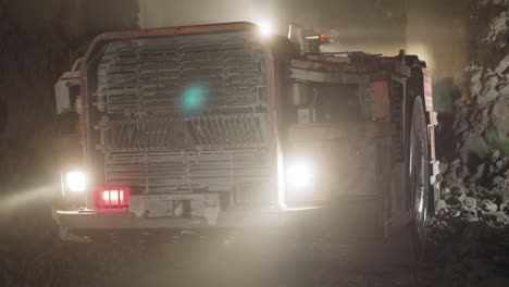 Large-transport-moves-in-ore-mine-illuminating-dark-area