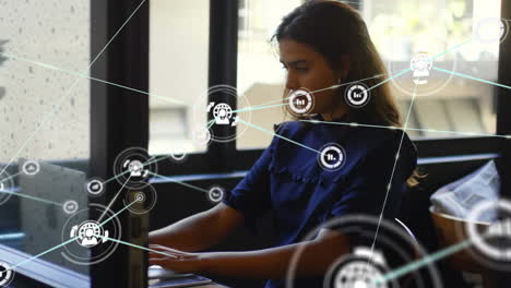 animación de una red de conexiones con iconos sobre una mujer de negocios usando una computadora portátil