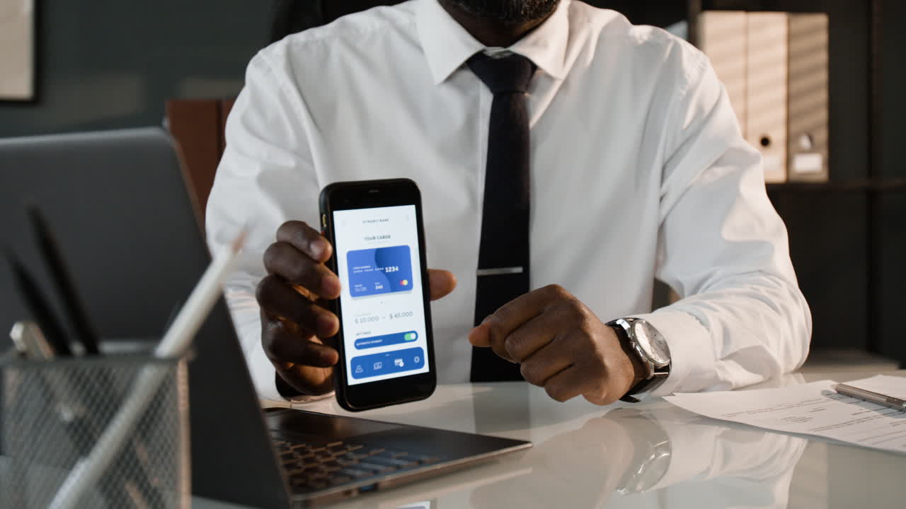 Businessman using mobile phone for digital payment in office
