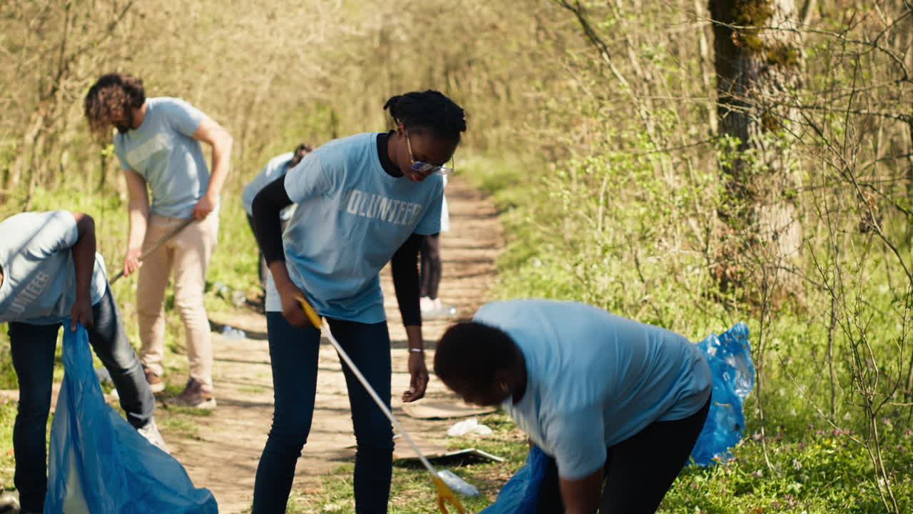 Environmental activists collecting rubbish and plastic waste in garbage bag