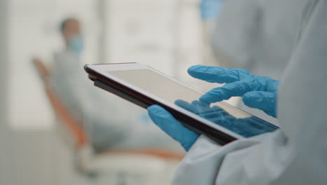 close up of hand using dental x ray on modern tablet