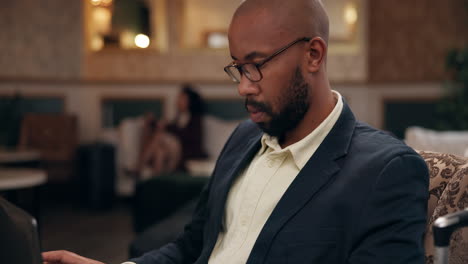 man working on laptop in hotel lobby