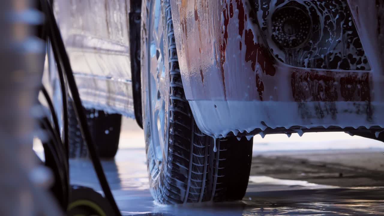 el jabón gotea por un vehículo y los neumáticos se lavan con jabón - imágenes en cámara lenta