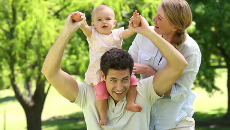padres felices con su niña en el parque