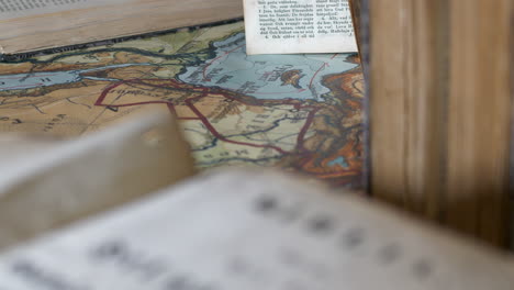 Old-Ancient-Bible-and-Map,-Tilt,-Close-Up