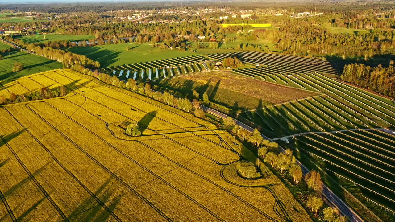 Aerial view of farmland and solar arrays in countryside during golden sunset hour