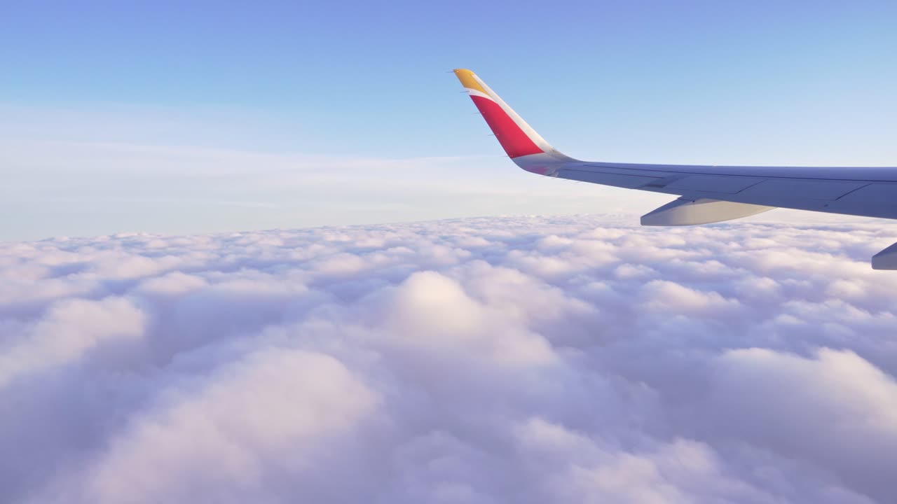 Ala di un aereo che vola sopra le nuvole in un bellissimo pomeriggio luminoso.