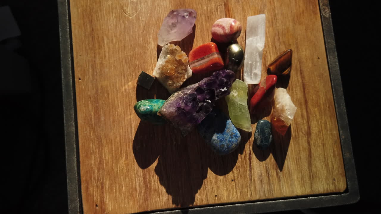 Medium close shot looking downwards at gemstones displayed on top of a wooden box