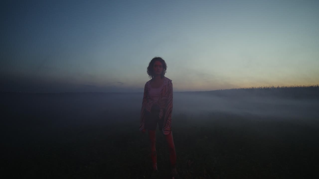 mujer en un campo al anochecer