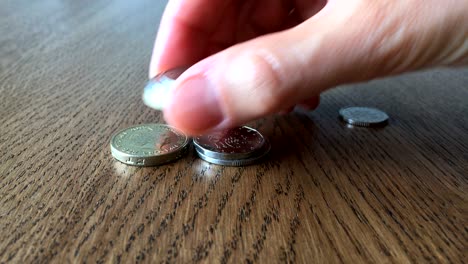 el concepto de dinero en crecimiento. la mano de la mujer puso monedas en la mesa.